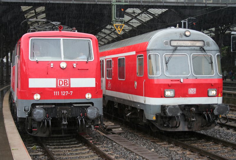 Links 111 127-7 mit dem RE4 ( Aachen - Dortmund ) & ein Silberling Steuerwagen Karlsruher Bauart verkehren an einem regnerischen 23.07.2009 in Aachen HBF
