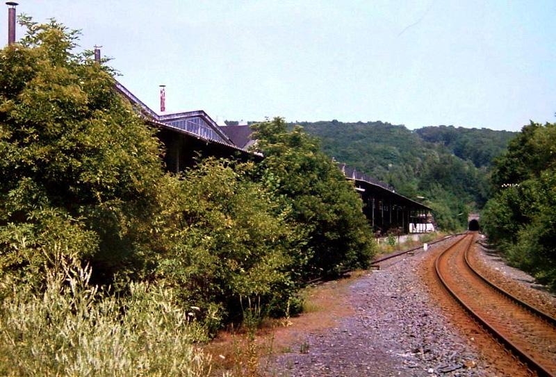 Links die Fabrikationshallen der ehemaligen Saarwerke mit Anschlugleis und Laderampe, im Hintergrund der Hasselborner Tunnel, 1. Hlfte der 1980iger Jahre.