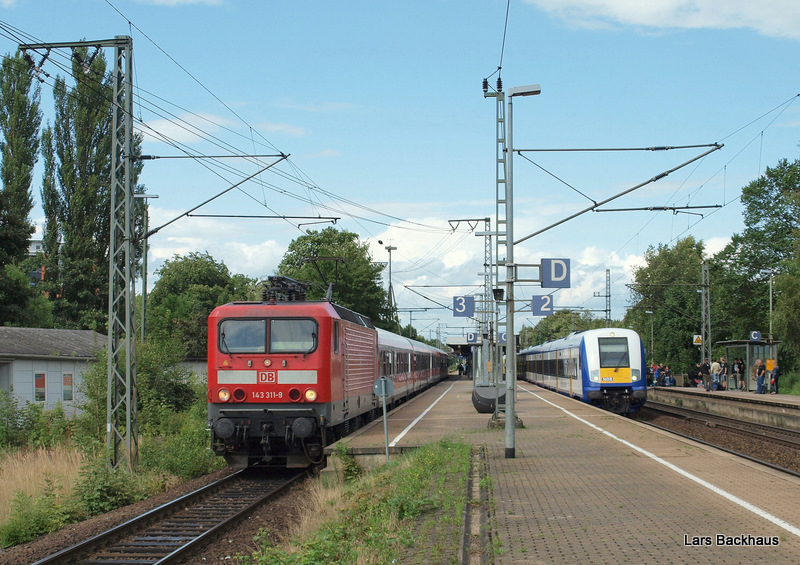 Links fhrt 143 311-9 mit einer unbekannt gebliebenen RB Richtung Hamburg aus und rechts steht die NOB 80518 nach Westerland/Sylt, die aber wegen einer Streckensperrung zwischen Itzehohe und Glckstadt ab Elmshorn ausfllt. Aufgenommen am 30.07.09 in Elmshorn.