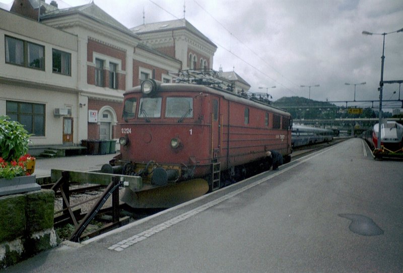 Lok EL 13 2124 im Bahnhof von Kristiansand. Von der Lok verdeckt ein Elektrotriebzug vom Typ 73  Signature . Rechts steht ein Zug vom Typ 73B. 