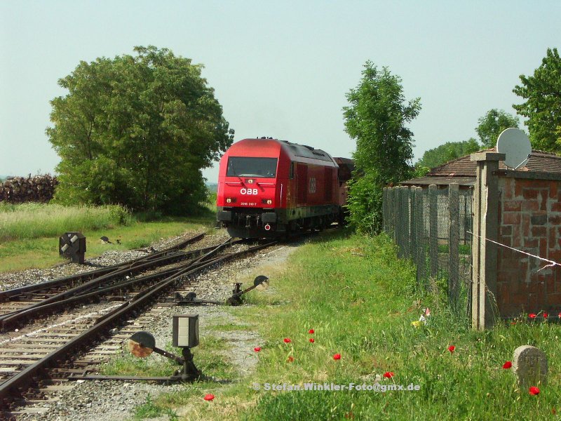 Lokalbahn-Atmosphre in sterreich, 60 Km von Wien. Direkt am Bahnhof des Stdtchens Mannersdorf am Leithagebirge liegt ein Tradionsreiches Zementwerk, das auch heute noch per Bahn bedient wird. Frher gab es von dort eine lange Drahtseilbahn zum Steinbruch oberhalb des Ortes, heute ist es ein gekapseltes Frderband. Zurck zum Bild. Wie sehen die neue 2016.010, wie Sie einen Kohlen-Ganzzug in den Anschluss des Werkes aus dem Bahnhof drckt. Hinter dem Grundstck rechts ist ein B, dann das Werk. Dort wir die Fuhre von einem 2-Wege-Unimog rangiert, die Lok nimmt fertige Wagen mit zurck. Mir gefllt das Bild, das eigentlich ein Schnellschuss ist, wegen vieler Details sehr gut.