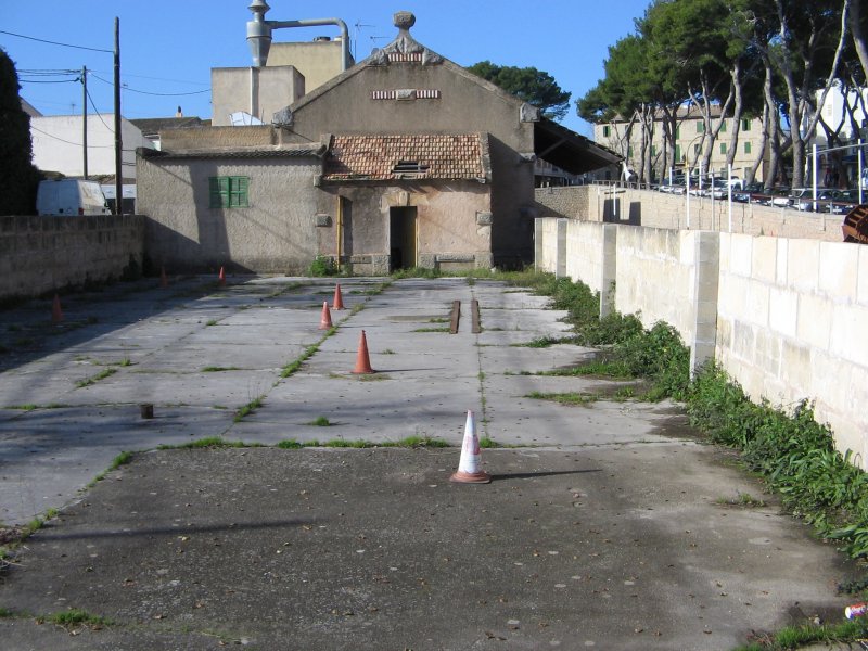 Mallorca/Arta,03.01.06,ehemaliges Kohlelager aus der Dampflokzeit,dahinter das Lagerhaus.Im rechten/oberen Bildteil endete die Strecke Palma-Manacor-Arta.Vor fast 30 Jahren fuhren hier noch MAN-Dieseltriebwagen,dann kamen die Reisebusse.....
Eine Wiederinbetriebnahme ist immer wieder im Gesprch.So wurden auch die beiden Strecken Inca-Sa Pobla und Inca-Manacor vor wenigen Jahren wieder aktiviert.Die im Sommer neu gewhlte Inselregierung wird nach eigenen Angaben den Autobahnbau beenden und den PNV weiter ausbauen.