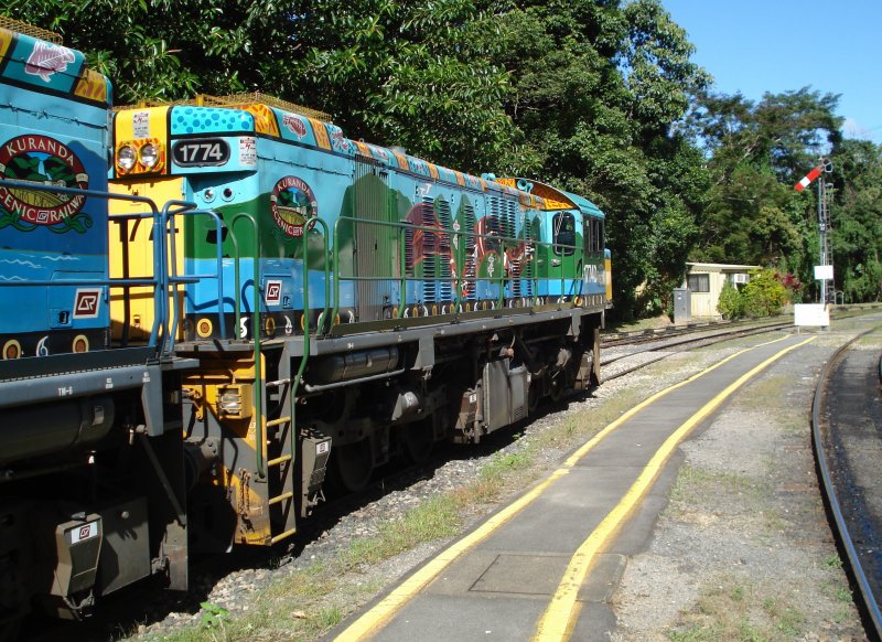 Maschine 1774 der Class 1720 im Bahnhof Kuranda am 11.04.08. An den Seiten der Lokomotive erkennt man  Buda-dji  - die Teppichpython - , die fr die Ureinwohner in der Region Cairns fr die Entstehung der Wlder, Berge und Flsse verantwortlich ist.
