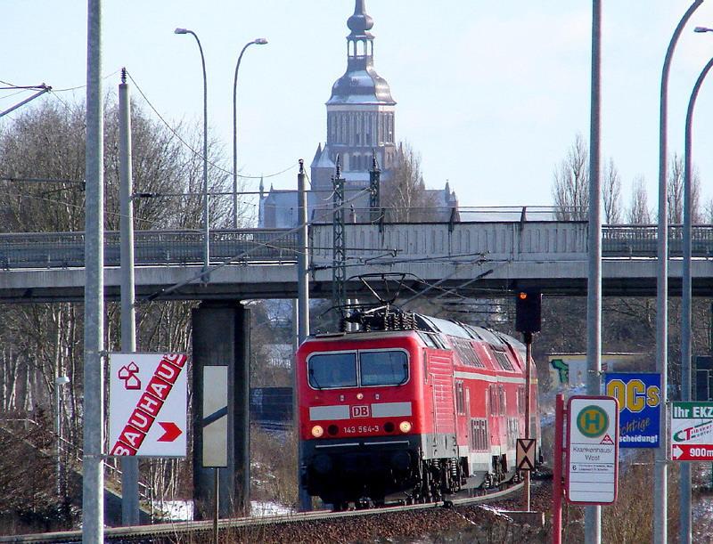 Mastenwald & Kirchensilhouette. 143 564-3 vor dem RE33210 nach Rostock .  (Stralsund am 26.02.06) 
