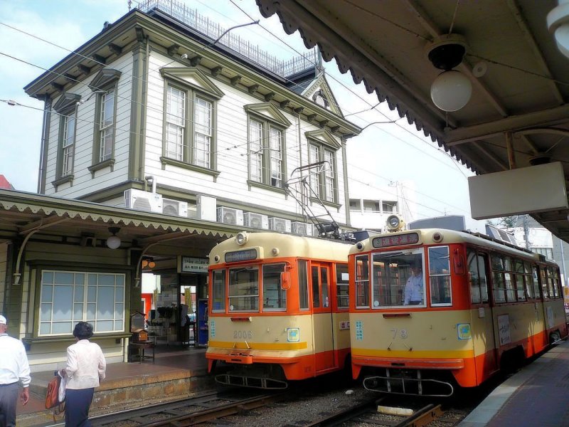 Matsuyama Strassenbahn, Serie 70-78: Wagen 78 ist gerade an der Endstation bei den Heissen Quellen von Dgo (Dgo Onsen) angekommen. Wagen 2006 steht abfahrbereit daneben. Das aus dem Jahr 1911 stammende, schn restaurierte Stationsgebude strahlt die Atmosphre frher Bauten im westlichen Stil aus. 18.September 2009. 