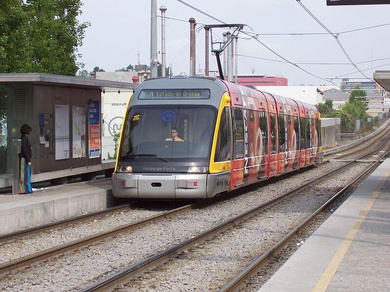 Metrozug mit Werbung der Linie A von Matosinhos nach Estadio do Dragao f�hrt am 10.05.2006 in die Station Francos ein, im Hintergrund die Schornsteine einer Kaffeer�sterei, man roch es!