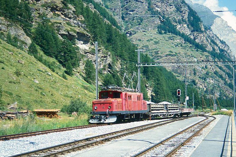 MGB BVZ DIENSTGTERZUG 5168 von St.Niklaus nach Tschsand am 02.08.1994 Einfahrt Tsch mit Zahnrad-E-Lok HGe 4/4I 15 - Fak 2773 - Kkl 2691.
