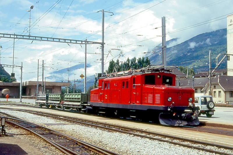 MGB BVZ EXTRAGTERZUG 4138 von St.Niklaus nach Visp am 09.06.1995 Einfahrt Visp mit Zahnrad-E-Lok HGe 4/4I 11 - Fak 2773 - F 2794. Hinweis: Im Gterbahnhofbereich Visp befindet sich eine Abladerampe fr Schttgut von Lkw auf Gterwagen..
