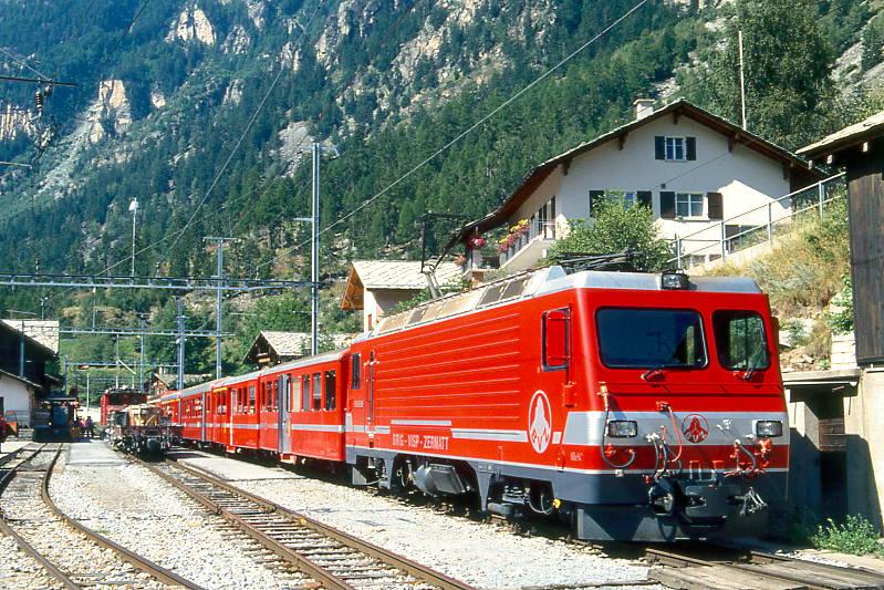 MGB BVZ GLACIER-EXPRESS C 904 von Zermatt nach St.Moritz am 02.08.1994 in St.Niklaus mit Zahnrad-E-Lok HGe 4/4II 1 - B 2262 - AB 2163 - B 2285 - A 2072 - FO AS 4027 - RhB B 2427 - RhB B 2422. Hinweis: BVZ und FO-Fahrzeuge noch in alter Lackierung!
