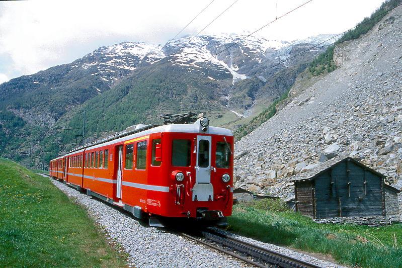 MGB BVZ REGIONALZUG 136 von Zermatt nach Brig am 21.05.1997 im Bergsturzgebiet Randa mit Zahnrad-Doppeltriebwagen ABDeh 8/8 2041 - B 2261 - A 2066. Hinweis: Die groblttrigen grnen Pflanzen im Vordergrund ist Gelber Enzian. Der Zug befindet sich auf der neu gebauten Bergsturzumfahrungsstrecke. Der Bergsturz von Randa fand am 18.04.1991 und am 19.05.1991 statt. Etwa 30 Mio. m Felsmassen strzten zu Tal und verschtteten die einzige Zufahrtsstrae und Bahnlinie nach Zermatt samt den Weiler Lrch. Die Schuttmassen sperrten den Abfluss der Matter und der oberhalb der Bergsturzstelle liegende untere Ortsteil Randa wurde am 16.06.1991 berschwemmt. Die Felsmassen begruben 35 Schafe, 7 Pferde und 33 Landwirtschaftsgebude und Ferienhuser unter sich. Randa liegt im tiefsten Taleinschnitt Europas etwa 3100m tief zwischen Dom und Weisshorn. Weitwinkelaufnahme
