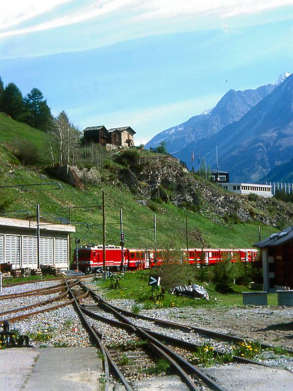 MGB BVZ SCHNELLZUG 103 von Brig nach Zermatt am 23.05.1997 kurz vor Zermatt mit Zahnrad-E-Lok HGe 4/4II 3 - A 2066 - B 2261 - B 2269 - B 2262 - DZ.2353. Hinweis: Sicht auf ungeschtzte Einfahrtsgleise des Gterbahnhofes. Links ist die gesicherte Zufahrt nach Zermatt mit Schafgrabengalerie sichtbar.
