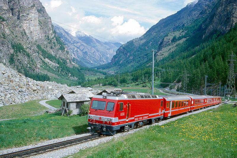 MGB BVZ SCHNELLZUG 105 von Brig nach Zermatt am 21.05.1997 im Bergsturzgebiet Randa mit Zahnrad-E-Lok HGe 4/4II  5 - AD 2078 - B 2289 - B 2251 - A 2055. Hinweis: Zug befindet sich auf der neu gebauten Bergsturzumfahrungsstrecke. Der Bergsturz von Randa fand am 18.04.1991 und am 19.05.1991 statt. Etwa 30 Mio. m Felsmassen strzten zu Tal und verschtteten die einzige Zufahrtsstrae und Bahnlinie nach Zermatt samt den Weiler Lrch. Die Schuttmassen sperrten den Abfluss der Matter und der oberhalb der Bergsturzstelle liegende untere Ortsteil Randa wurde am 16.06.1991 berschwemmt. Die Felsmassen begruben 35 Schafe, 7 Pferde und 33 Landwirtschaftsgebude und Ferienhuser unter sich. Randa liegt im tiefsten Taleinschnitt Europas etwa 3100m tief zwischen Dom und Weisshorn.
