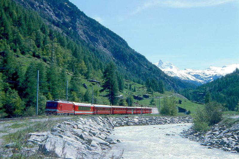 MGB BVZ SCHNELLZUG 108 von Zermatt nach Brig am 22.05.1993 bei Tschsand mit Zahnrad-E-Lok HGe 4/4II 4 - FO AS 4014 - B 2284 - RhB A 1254 - B 2273 - AB 2161 - B 2261. Hinweis: Blick ber die Matter nach Sden Richtung auf die Bergwelt von Zermatt.

