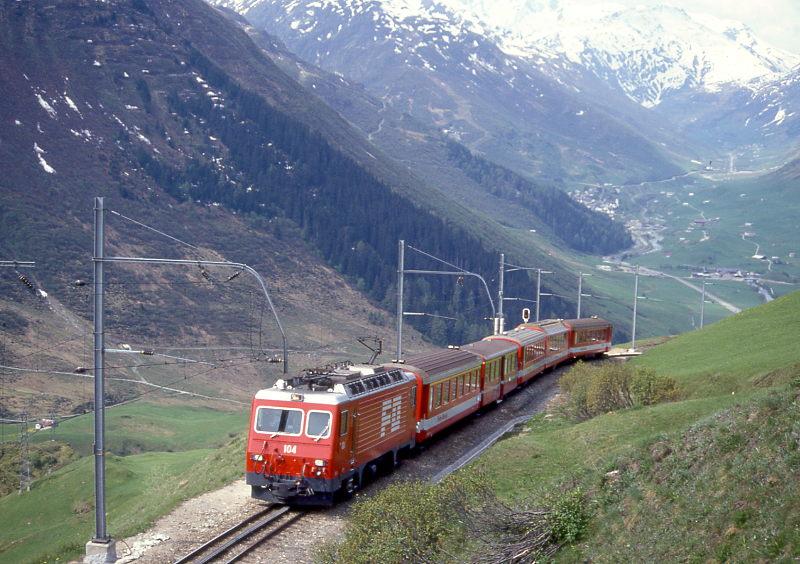 MGB exFO GLACIE-EXPRESS 900 von Brig nach Disentis am 28.05.1992 kurz vor Butzen-Kehrtunnel mit E-Lok HGe 4/4II 104 - A - BVZ A - B - AS - ABt. Hinweis: Blick auf Urserental mit Hospental
