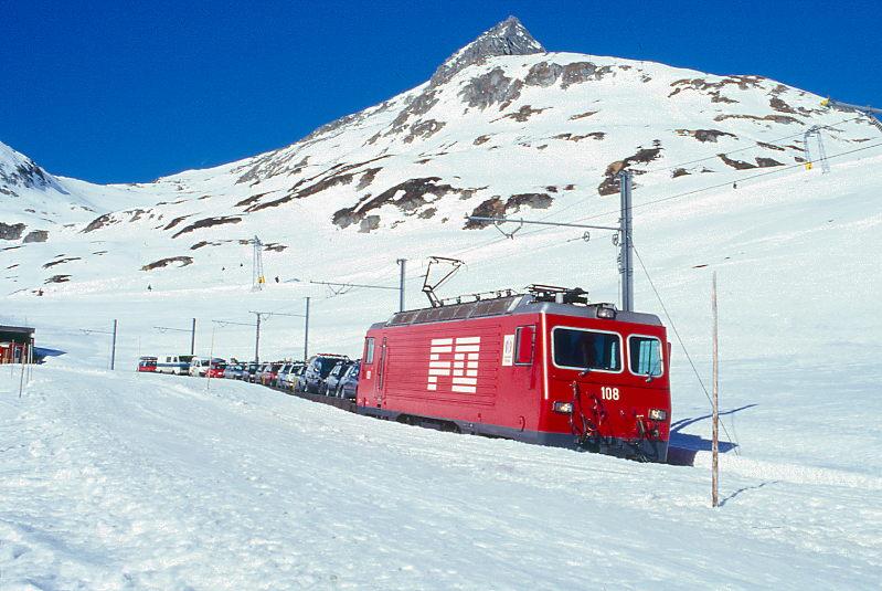 MGB FO-AUTOTRANSPORTZUG 4346 Von Andermatt nach Sedrun am 14.02.1998 kurz nach Oberalppasshhe-Galerie mit Zahnrad-E-Lok HGe 4/4II 108 - 6x Rw - RhB B 2213. Hinweis: Lok noch in alter Lackierung.
