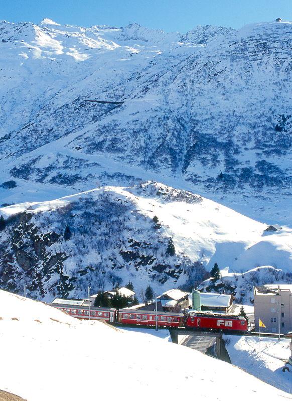 MGB FO-ENTLASTUNGSZUG 2347 von Disentis nach Andermatt am 15.02.1998 beim oberen Ortseingang von Andermatt mit Zahnrad-E-Lok HGe 4/4II 104 - RhB B 2212 - B 4268 - ABt 4195 - RhB B 2255 - B 4263 - D 4342. Hinweis: FO-Fahrzeuge noch in alter Lackierung.
