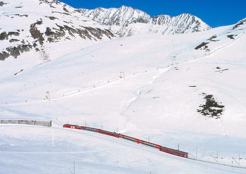 MGB FO-GLACIER-EXPRESS 903 von St.Moritz nach Zermatt am 14.02.1992 kurz vor Obreralppass-Galerie mit FO-Zahnrad-E-Lok HGe 4/4II 106 - BVZ AS - RhB B - FO AS - FO AS - RhB WR 3815. Hinweis: FO/BVZ-Fahrzeuge in alter Lackierung. Hinweis: alle Fahrzeuge noch in alter Lackierung. 1992 verkehrte im Winter nur ein Glacier-Express Zugpaar tglich.
