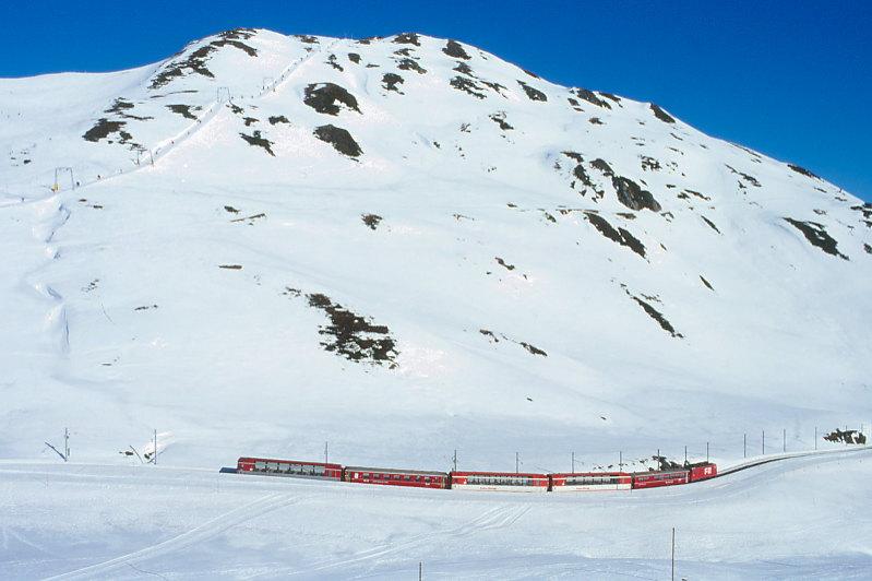 MGB FO-GLACIER-EXPRESS 906 von Zermatt nach St.Moritz am 14.02.1992 kurz vor Obreralppass-Calmot mit FO-Zahnrad-E-Lok HGe 4/4II 105 - RhB WR 3815 - FO AS - FO AS - RhB B - BVZ AS. Hinweis: FO/BVZ-Fahrzeuge in alter Lackierung. Hinweis: alle Fahrzeuge noch in alter Lackierung. 1992 verkehrte im Winter nur ein Glacier-Express Zugpaar tglich.
