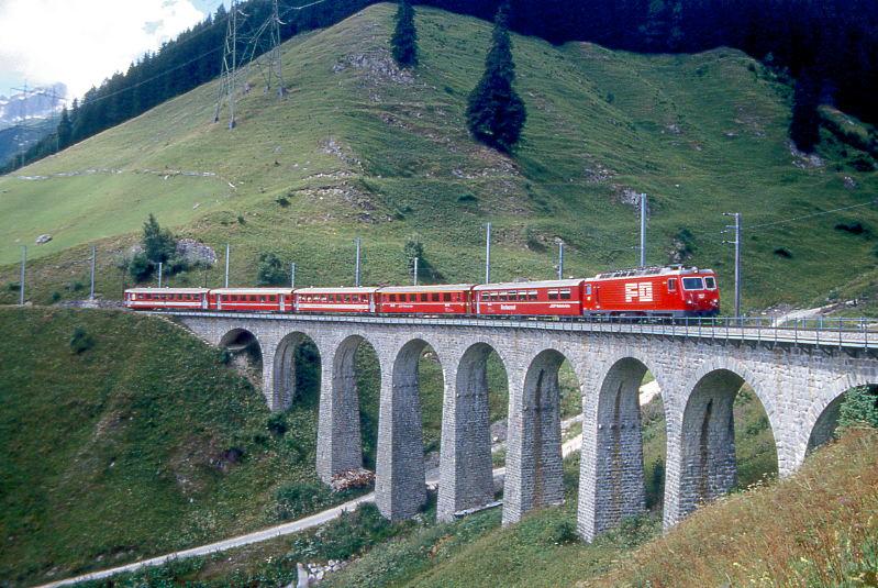 MGB FO-GLACIER-EXPRESS D 906 von Zermatt nach Chur am 04.08.1992 auf Bugnei-Viadukt mit FO-Zahnrad-E-Lok HGe 4/4II 107 - RhB WR 3815 - RhB A 1254 - FO B 4269 - BVZ A 2072 - FO B 4268. Hinweis: FO/BVZ-Fahrzeuge in alter Lackierung, Viadukt vor Umbau.

