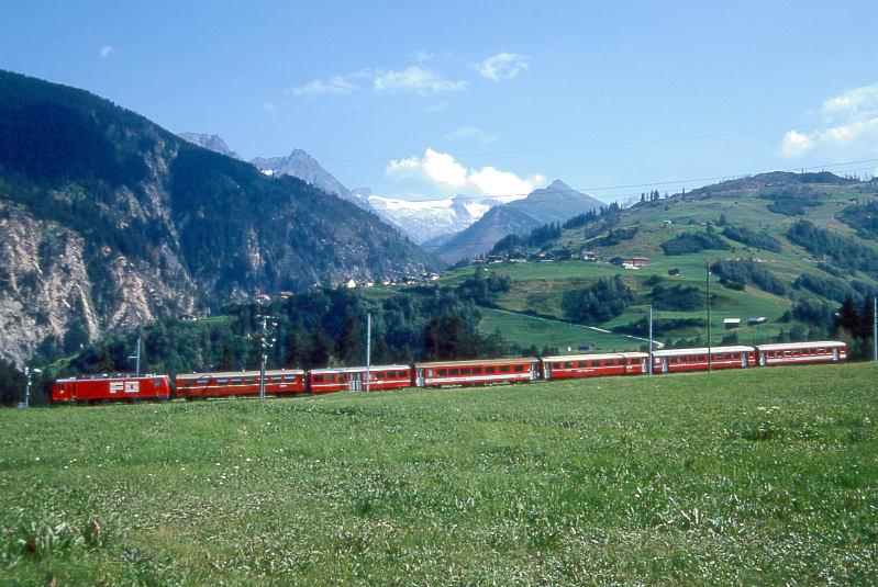 MGB FO-GLACIER-EXPRESS D 906 von Zermatt nach Chur am 07.08.1992 bei Acla im 90-Promille Zahnstangenabschnitt Segnas-Disentis mit FO-Zahnrad-E-Lok HGe 4/4II 107 - RhB WR 3811 - BVZ B 2263 - FO AB 4172 - RhB A 1255 - FO B 2283 - FO B 4255. Hinweis: FO/BVZ-Fahrzeuge und Speisewagen in alter Lackierung, Blick Richtung Sden zum Medel-Gletscher und Lukmanier-Gebiet
