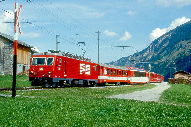 MGB FO-GLACIER-EXPRESS K 2907 Nachfhrung von Chur nach Zermatt am 05.09.1997 bei Segnas mit FO-Zahnrad-E-Lok HGe 4/4II 108 - FO B 4267 - FO AS 4027 - RhB B 2445 - FO B 4271 - RhB B 2433 - BVZ B 2284. Hinweis: FO-Fahrzeuge in alter Lackierung.

