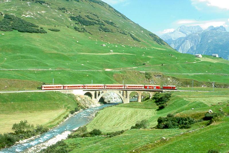 MGB FO-REGIONALZUG 230 von Brig nach Andermatt am 24.08.1997 auf Richleren-Viadukt mit Zahnrad-E-Lok HGe 4/4I 33 - D 4343 - B 4267 - B 4272 - ABt 4159 - ABt 4194 - B 4265. Hinweis: FO-Fahrzeuge in alter Lackierung.
