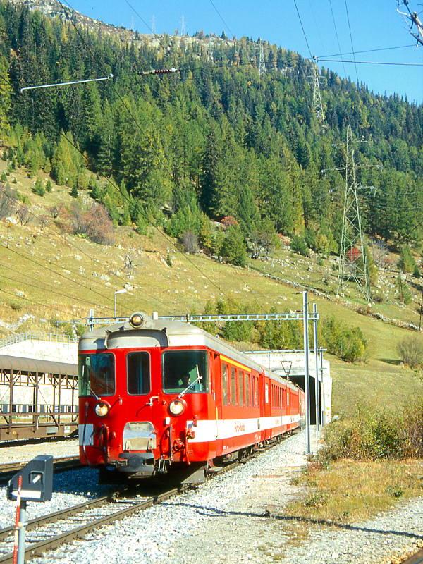 MGB FO-REGIONALZUG 233 von Andermatt nach Brig am 10.10.1995 Einfahrt Oberwald, Steuerwagen vorraus mit ABt 4151 - B 4251 - B 4252 - Zahnradtriebwagen Deh 4/4II 93 schiebend.Hinweis: Fahrzeuge noch in alter Lackierung. Im Hintergrund ist das Portal des Umfahrungstunnel Oberwald sichtbar.
