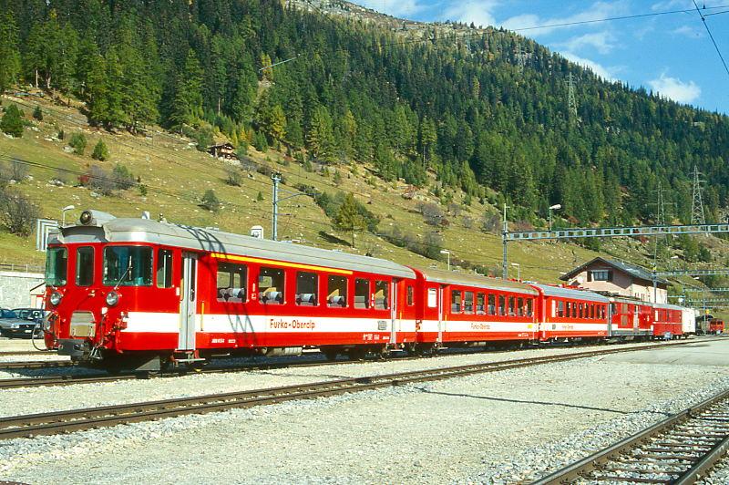 MGB FO-REGIONALZUG 31 von Oberwald nach Brig am 11.10.1996 in Oberwald, Steuerwagen vorraus mit ABt 4154 - B 4254 - B 4277 - Zahnradtriebwagen Deh 4/4I 54 schiebend - RhB Z 100 - Gbv 4435. Hinweis: Fahrzeuge noch in alter Lackierung. Z-Wagen in Ausland verkauft, am Zugschlu luft ein Velowagen mit.
