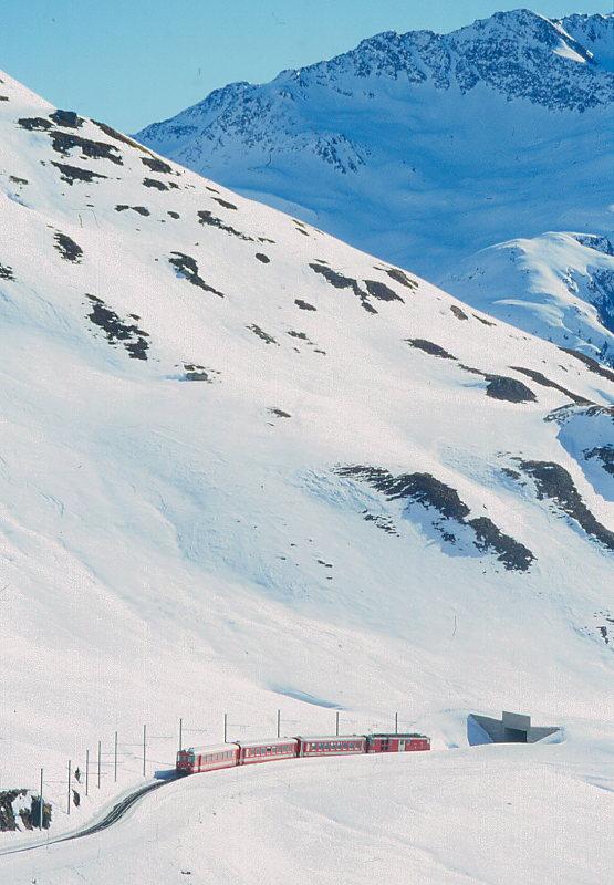 MGB FO-REGIONALZUG 330 von Andermatt nach Disentis am 14.02.1998 kurz nach Oberalppasshhe und vor Calmot II-Tunnel mit Zahnrad-Triebwagen Deh 4/4II 93 - B 4281 - B 4282 - ABt 4158. Hinweis: Fahrzeuge noch alte Lackierung.
