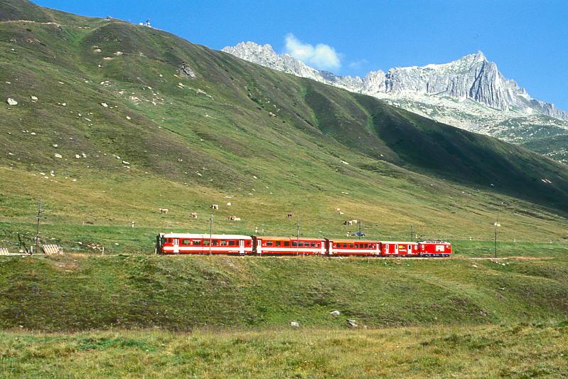 MGB FO-REGIONALZUG 334 von Andermatt nach Disentis am 24.08.1997 oberhalb Ntschen Richtung Oberalppass mit Zahnrad-Lok HGe 4/4II 103 - DZ 4354 - AB 4172 - AB 4171 - Bt 4291. Hinweis: Fahrzeuge noch in alter Lackierung.
