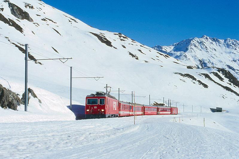MGB FO-REGIONALZUG 367 von Disentis nach Andermatt am 14.02.1998 kurz vor Oberalppass-Hhe mit Zahnrad-E-Lok HGe 4/4II 101 - B 4266 - ABt 4159 - RhB B 2255 - B 4264 - D 4341. Hinweis: FO-Fahrzeuge noch in alter Lackierung. Im Hintergrund ist Tunnel Calmot II erkennbar. Die Passstrae ist eine Schlittelbahn. 
