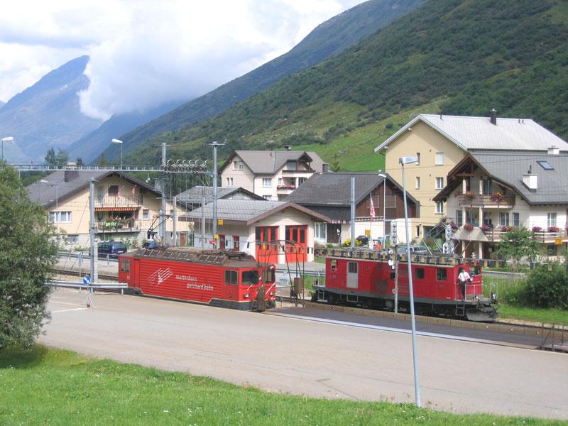 MGB-Lok Ge 4/4 82 mit einem auffahrbereiten Autozug in Realp. Dahinter rangiert die FO-Lok HGe 4/4 I Nr. 33 - 13.08.2005
