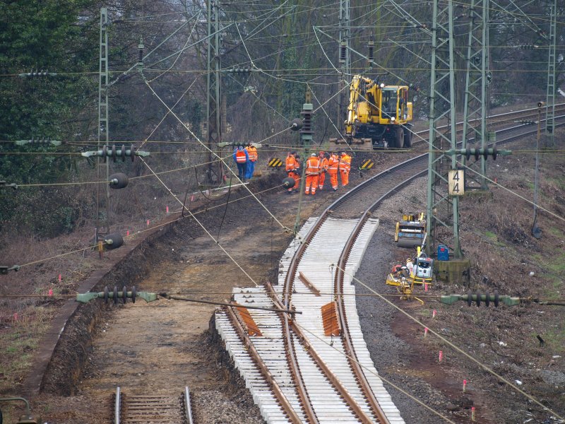 Mit einem 2WegeBagger wird am Aachener Westbahnhof auf der Strecke nach Belgien das alte Gleisbett ausgebaggert um eine neue Weiche einzubauen. Eine Weiche ist schon mit Laschen und Zwingen an dem alten Gleis angeschlossen und mu� nur noch angehoben und eingeschottert werden. 22.03.2009