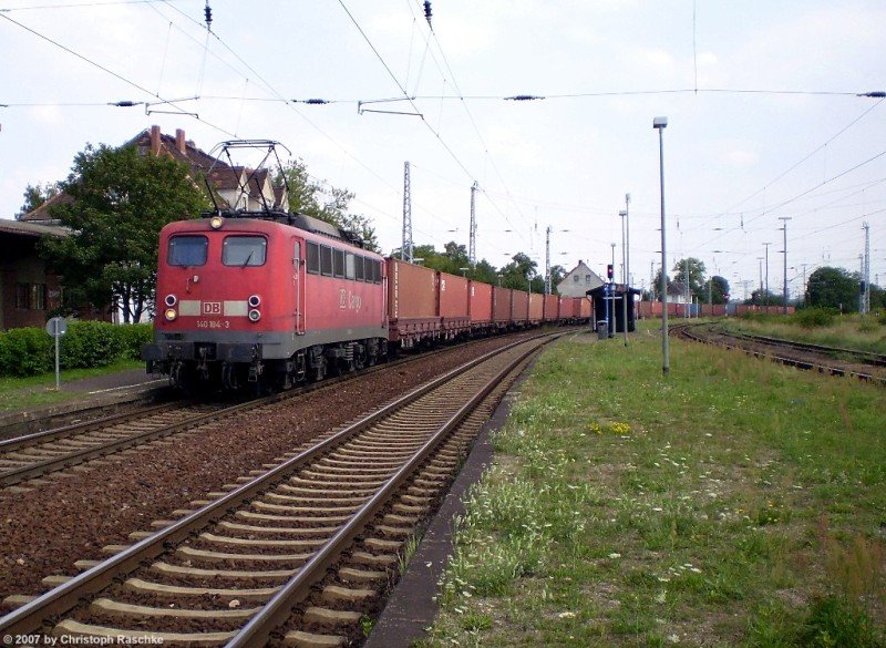 Mit einem defekten Licht kam die 140 184-3 mit einem Containerzug in Angersdorf bei Halle/Saale vorbei. (Angersdorf - 14.08.07)