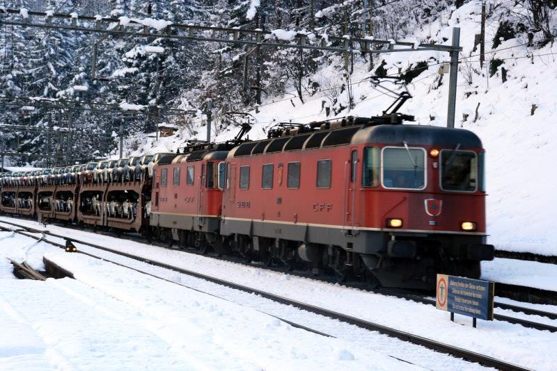 Mit einem Gru an den Fotografen steuert der Lokfhrer der Re 6/6 11603 in Doppeltraktion einer Re 4/4 eine Ladung Minis ber den Gotthard. Wassen, 07.12.2008