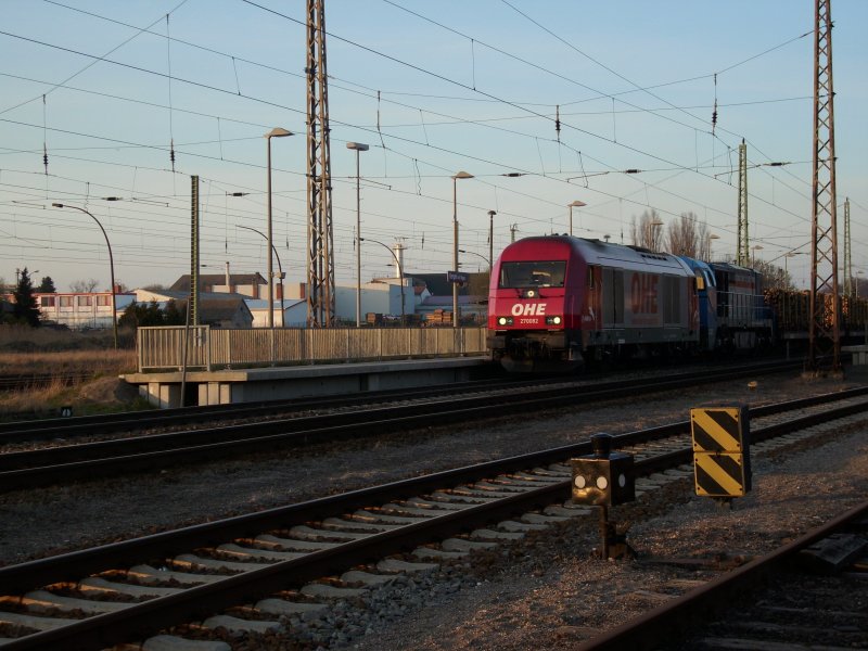 Mit einem Holzzug und einer G2000 im Schlepp ist OHE 270082 am 09.April 2009 bei der Durchfahrt durch Bergen/Rgen.