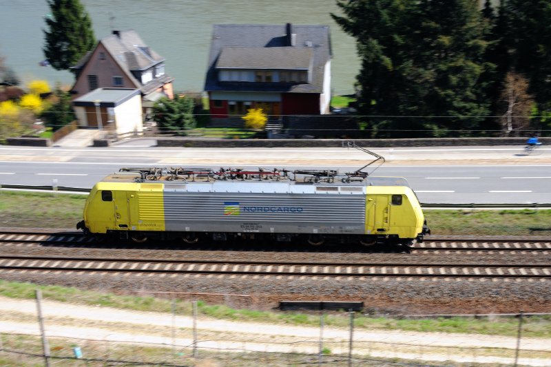 Mit einem wahnsinnigen Tempo jagt ES 64 F4 013  Nordcargo  St. Goar entgegen. (Mitzieher aufgenommen aus den Weinbergen kurz  nach Oberwesel a.R., April 2009).