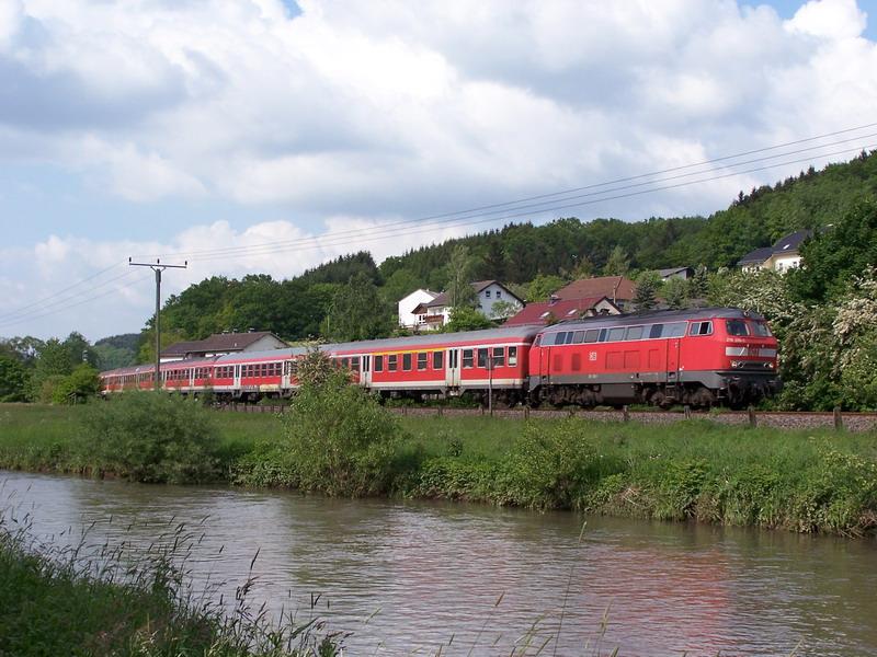 Mit RE 12085 Kln-Trier ist 218 206 am 02.06.06 am Densborner Kyllufer unterwegs. Die Lok hngt auerplanmig am Zugende Richtung Trier, normalerweise laufen die Loks auf der Klner Seite.