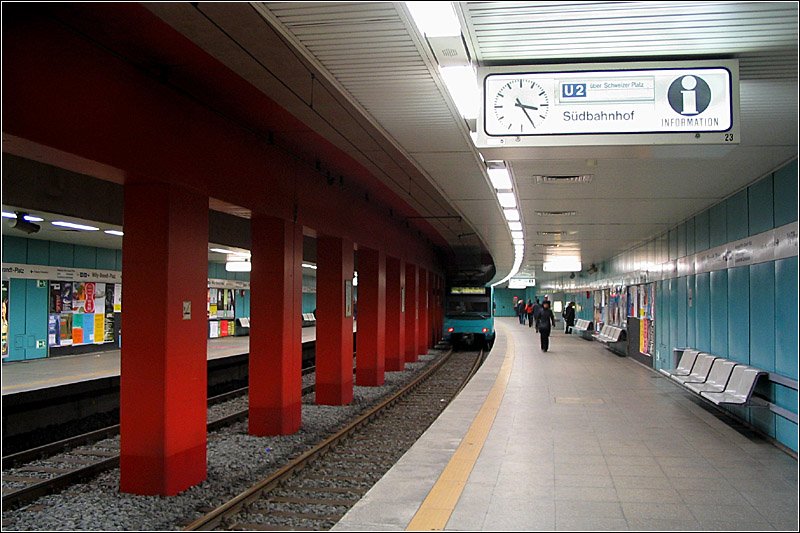 Mit roten Mittelstützen -

Willy-Brandt-Platz, 1974, Linien U1, U2, U3. Etwas farbenfroher präsentiert sich die obere Bahnsteigebene am Willy-Brandt-Platz. Dieser Stationsteil wurde zeitgleich mit der darunter liegenden Ebene gebaut, ging aber ein Jahr früher in Betrieb. Wegen der Nähe zur Main-Unterfahrung liegen diese Bahnsteige schon in der dritten Tiefebene. 

12.02.2005 (M)