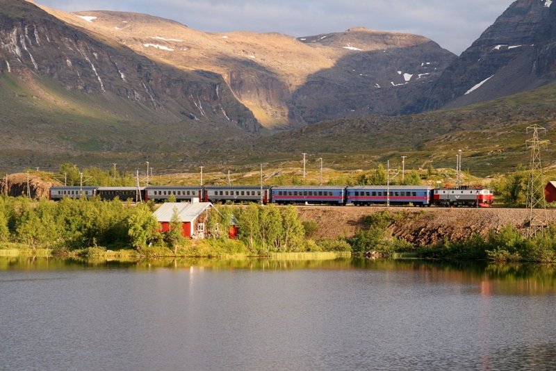 Mit ber einer Stunde Versptung passiert der mit einer Rc6 bespannte IC 96 (Stockholm-Narvik) am Abend des 05.August 2009 das beeindruckende Bergmassiv am Rande des Abisko-Nationalparks bei Vassijaure.