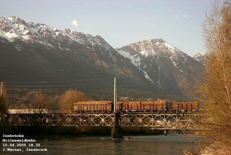 Mittenwaldbahn: duftendes Rundholz passiert die Innbrcke, im Hintergrunde leuchten Arzler Scharte und Rumerspitz. 15. April 2005