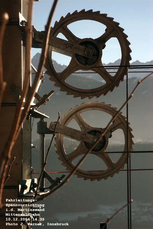 Mittenwaldbahn: Spannvorrichtung fr die Oberleitung, im Hintergrund die Nockspitze und die Kalkkgel, unten zu sehen die Kirche von Afling. Interessant die Faserstift-Markierungen  TS  und  FD ... sollten sich die Rollen in ihrer Dimension voneinander unterscheiden? 10. Dezember 2004