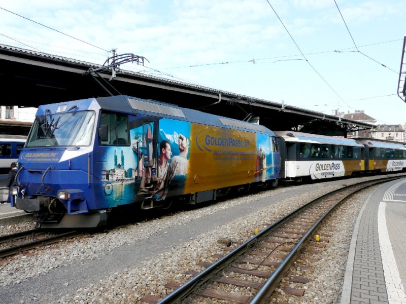 MOB - GOLDENPASS Schnellzug mit E-Lok Ge 4/4 8004 mit Werbung im Bahnhof von Montreux am 05.04.2008