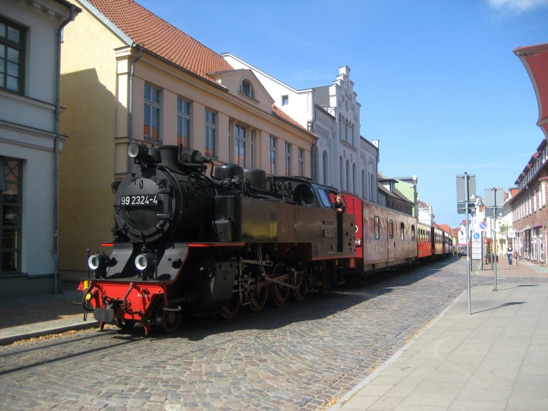 Molli zuckelt langsam durch die 
Innenstadt von Bad Doberan.
Lokomotive 99 2324-4 ist eine 
Neubaulokomotive, welche erst 2009
in Dienst gestellt wurde.
Wunderbarer nostalgischer 
Kleinbahnbetrieb.