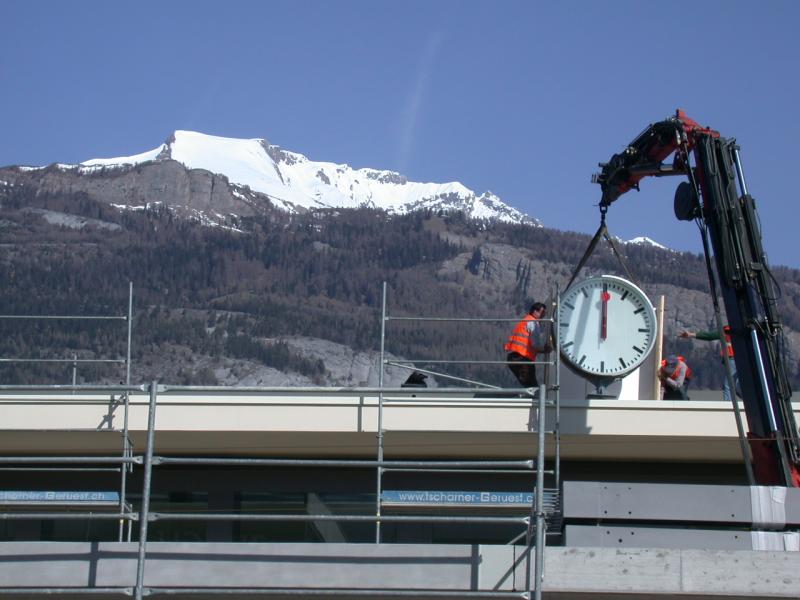 Montage der Bahnhofsuhr auf dem neuen Bahnhofsgebude in Chur. 
Im Hintergrund der frisch verschneite Haldensteiner Calanda.(03.05.2006)