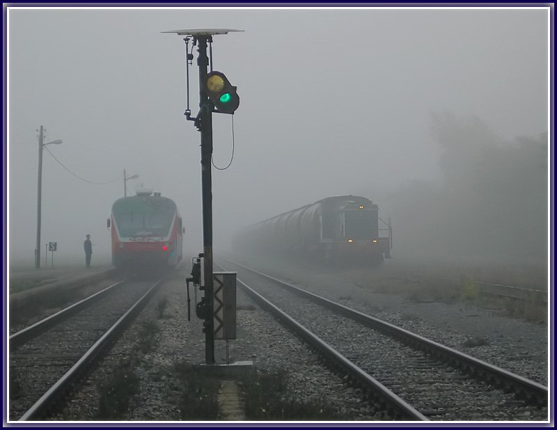 Morgennebel in Kidricevo am 12.10.2006. Triebwagen 814-123 als Regionalzug 3802 von Marburg nach Murska Sobota wartet auf seine Weiterfahrt whrend 642-DE  mit ihrem Kesselwagenzug auf die Bedienungsfahrt in das nahe gelegene Aluminiumwerk wartet.