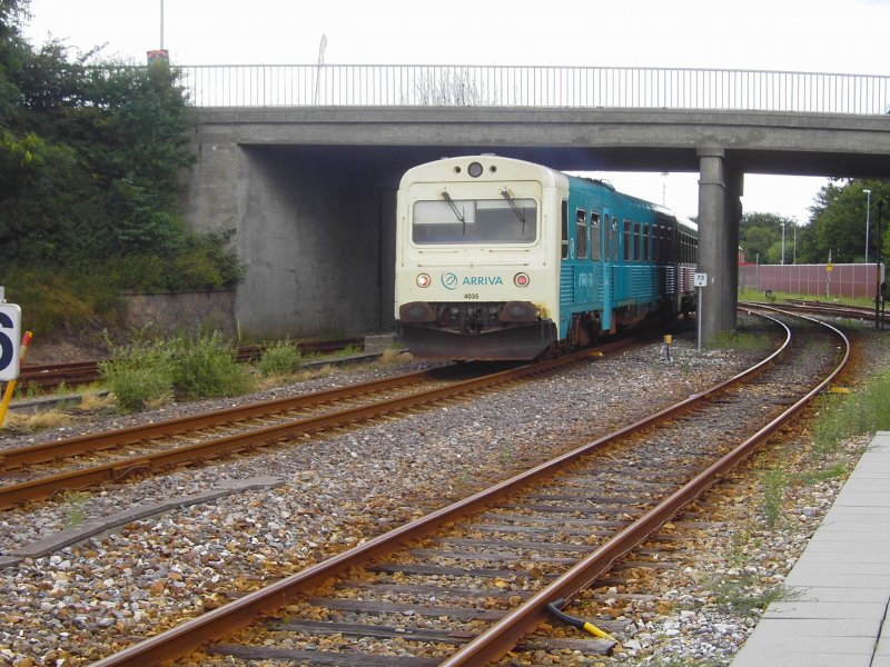 MR 4235, mit neuer Grn-Beige Lackierung, der Privatbahngesellschaft Arriva Tog A/S nach Skjern bei der Ausfahrt aus Varde unter der Straenbrcke am Bahnhof