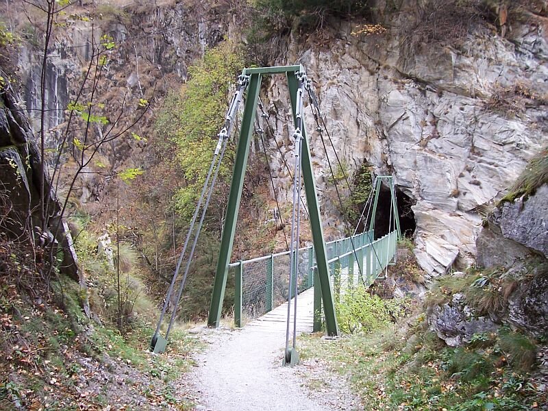 Nach dem 1.Tunnel kommt die 1.Hngebrcke ber das Baltschieder Tal, hier zu sehen und anschlieend der lngere 2.Tunnel, ihm folgt unmittelbar die 2.baugleiche Hngebrcke. Der 2.Tunnel macht eine Biegung, in der Mitte sieht man fast nichts, deshalb ist ein Fhrungsgelnder angebracht, ich wre aber beinah mit Gegenverkehr zusammen gestoen. Aufgenommen am 09.11.2006.