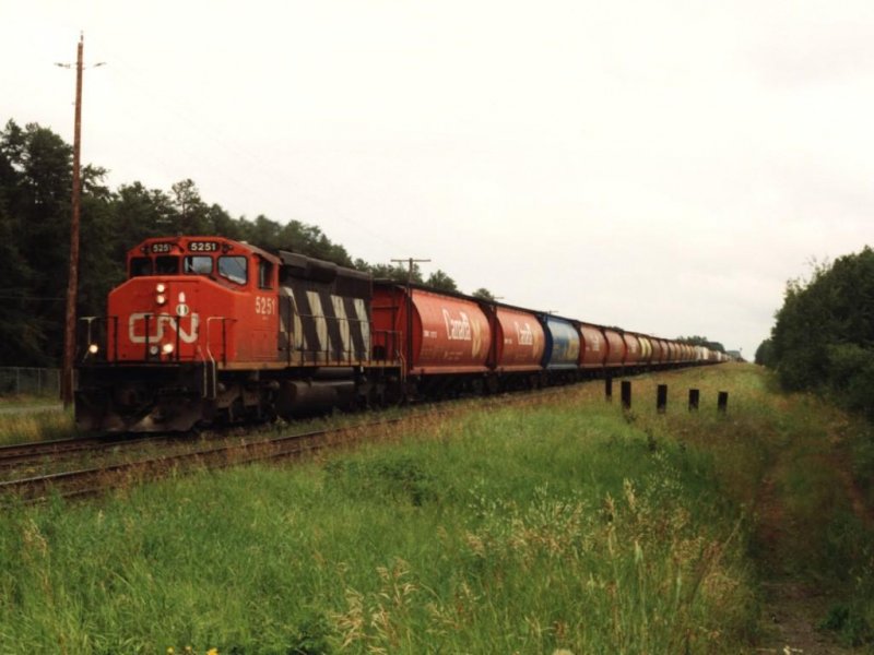 Nach fast sechs Monaten endlich wieder  Neuigkeiten  aus Kanada. Lok 5251 mit 100 waggons bei Twin City am 05-08-1993. Bild und scan: Date Jan de Vries.