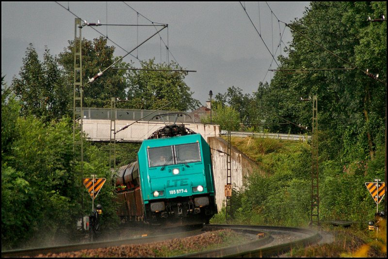 Nachdem es wieder geschttet hat, rollt 185 577 der LTE mit dem Httensandzug aus Linz-Stahlwerke bei Kiefersfelden in Richtung Kufstein. (02.08.2009)
